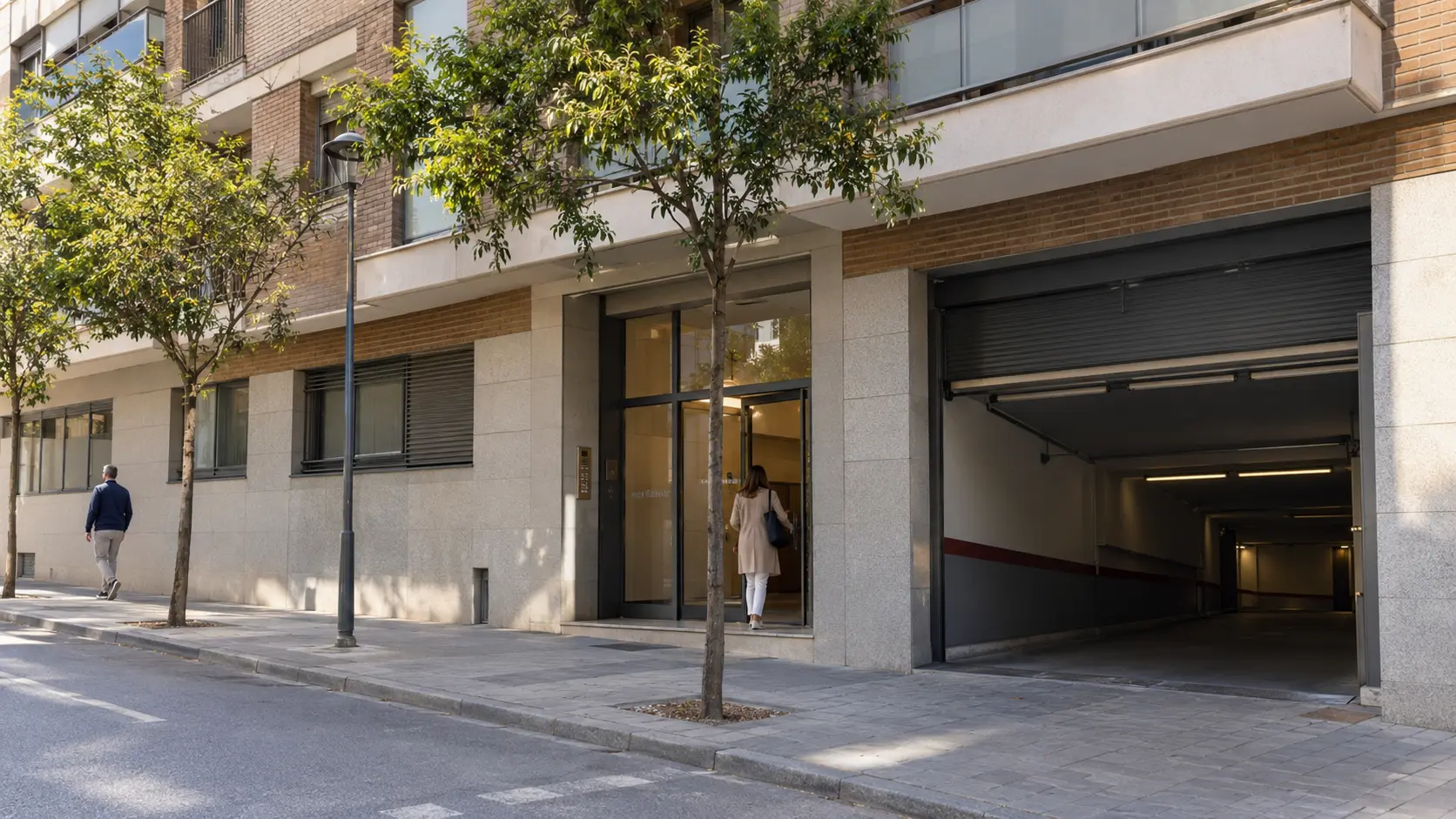 Portal y acceso al garaje de un edificio residencial vistos desde la calle